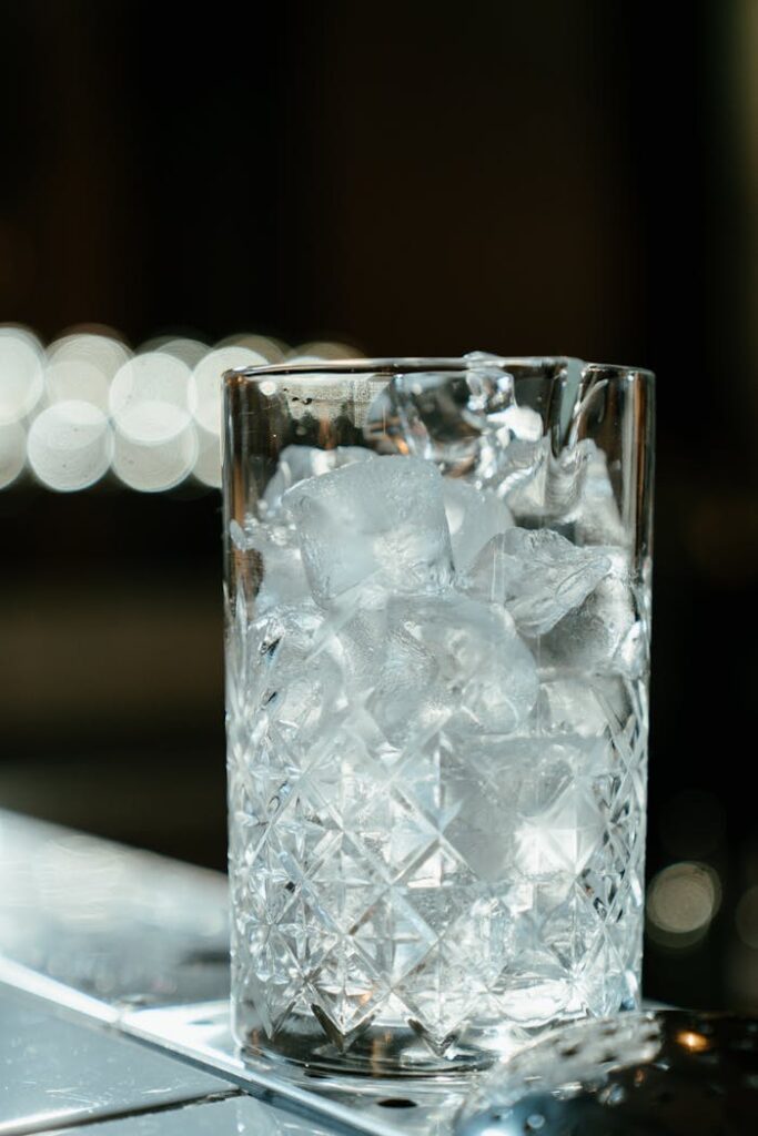 Clear Cut Drinking Glass on Brown Wooden Table